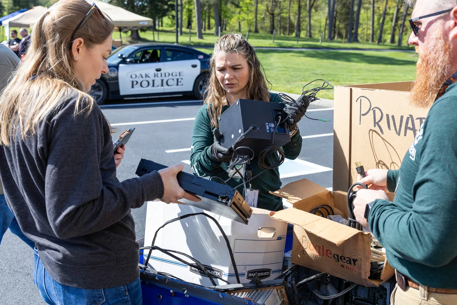 A group of employees recycles old electronics during a recycling event