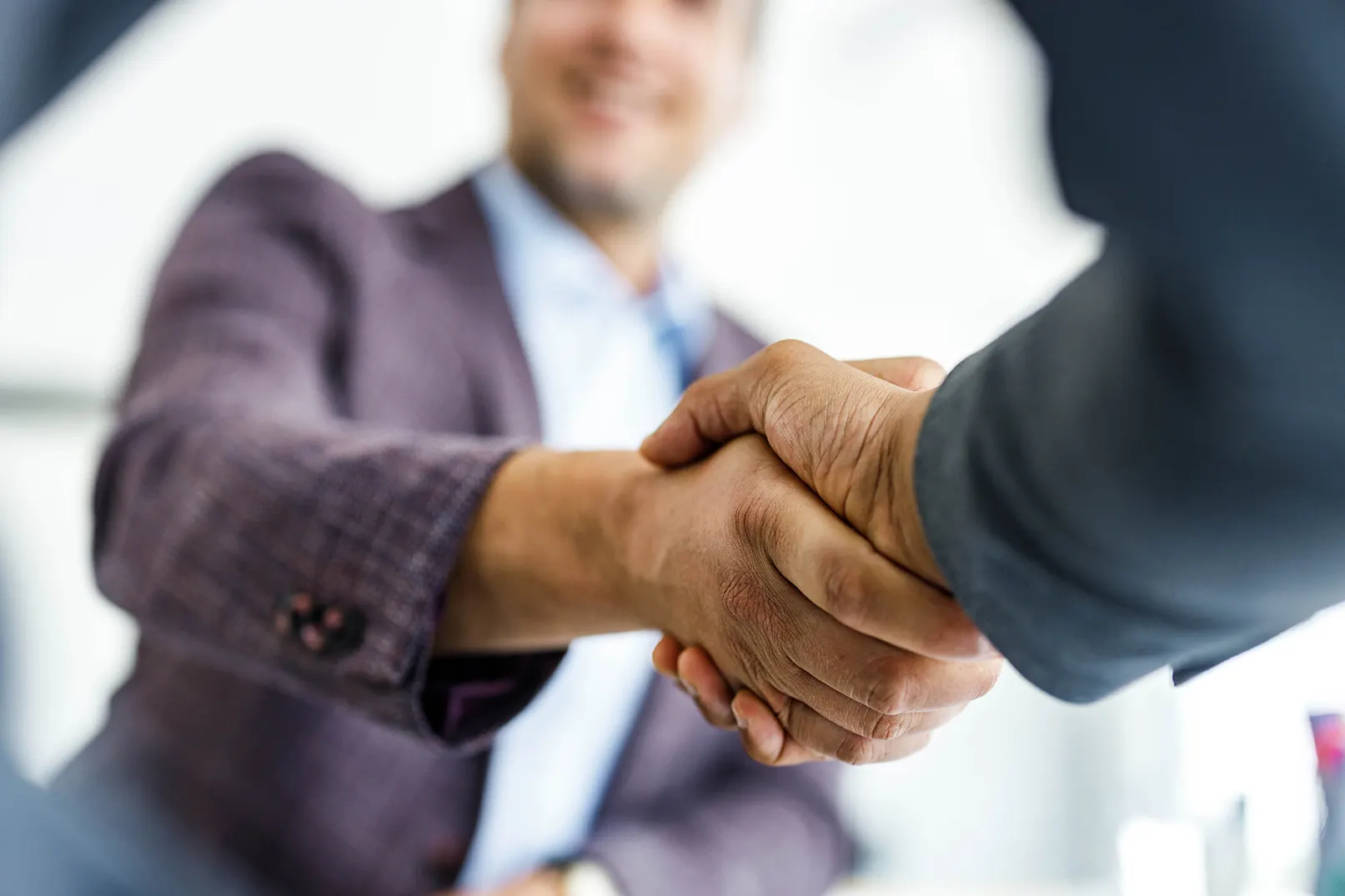 Close up of unrecognizable businessmen shaking hands after reaching an agreement in the office