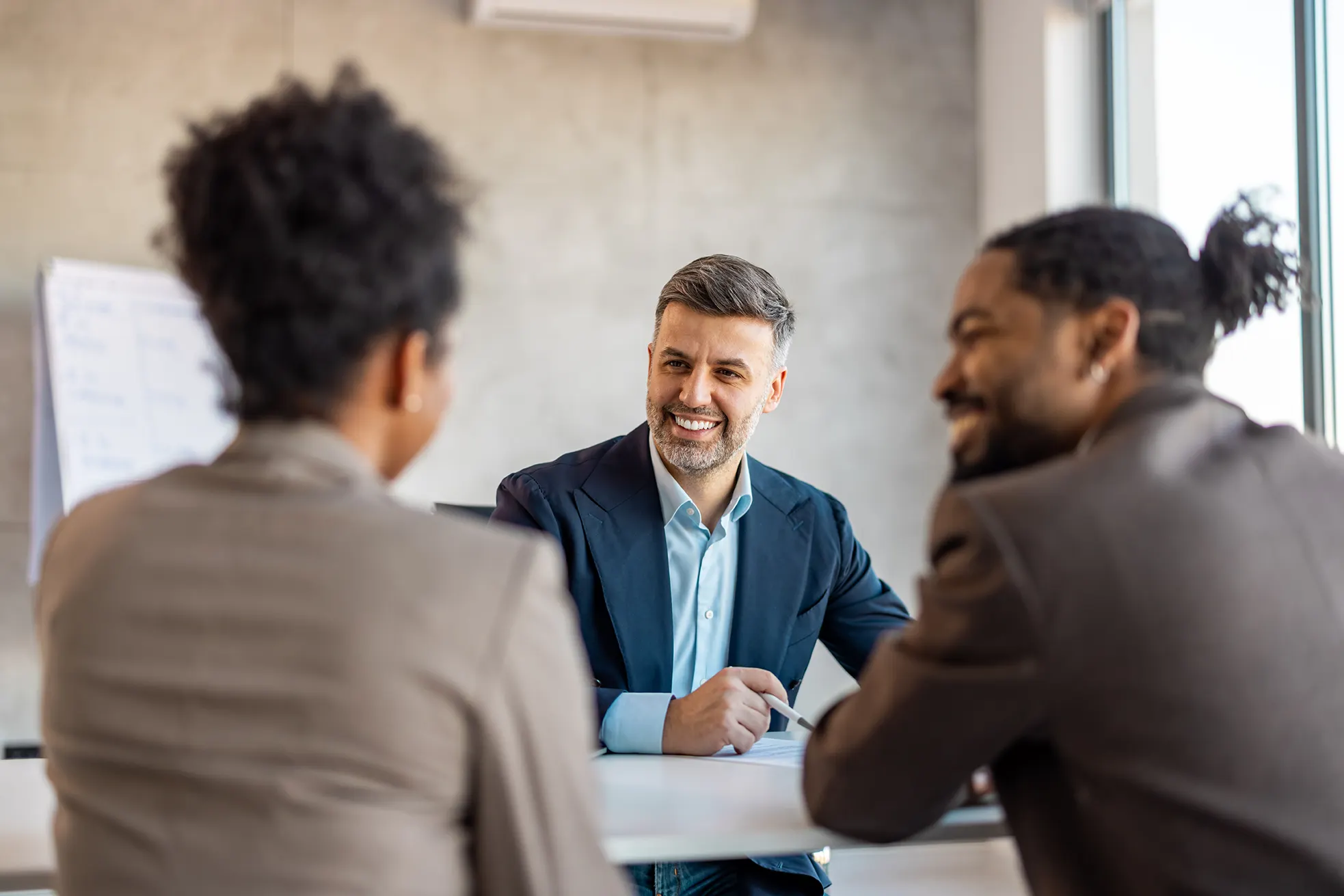 A group of three people hold a business meeting