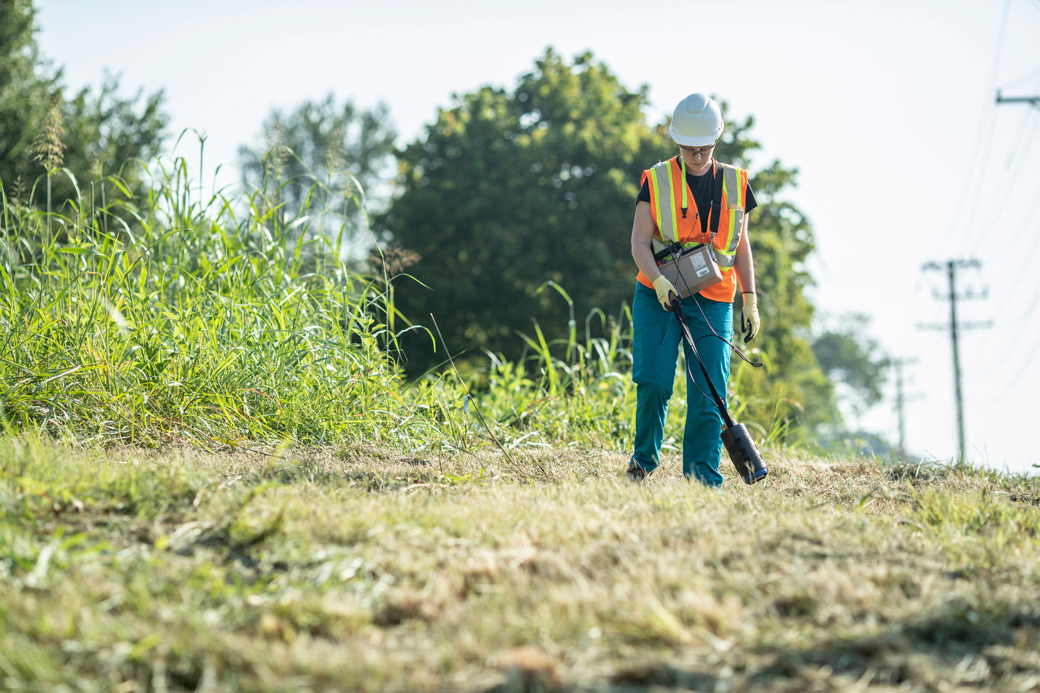 A health physicist records data during an outdoor radiation survey