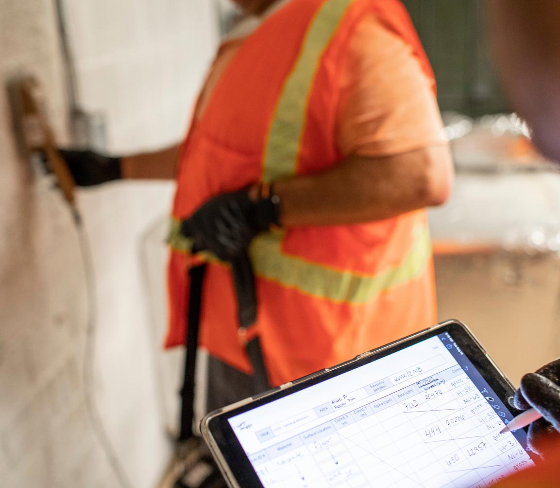 A health physicist records data during an indoor radiation survey