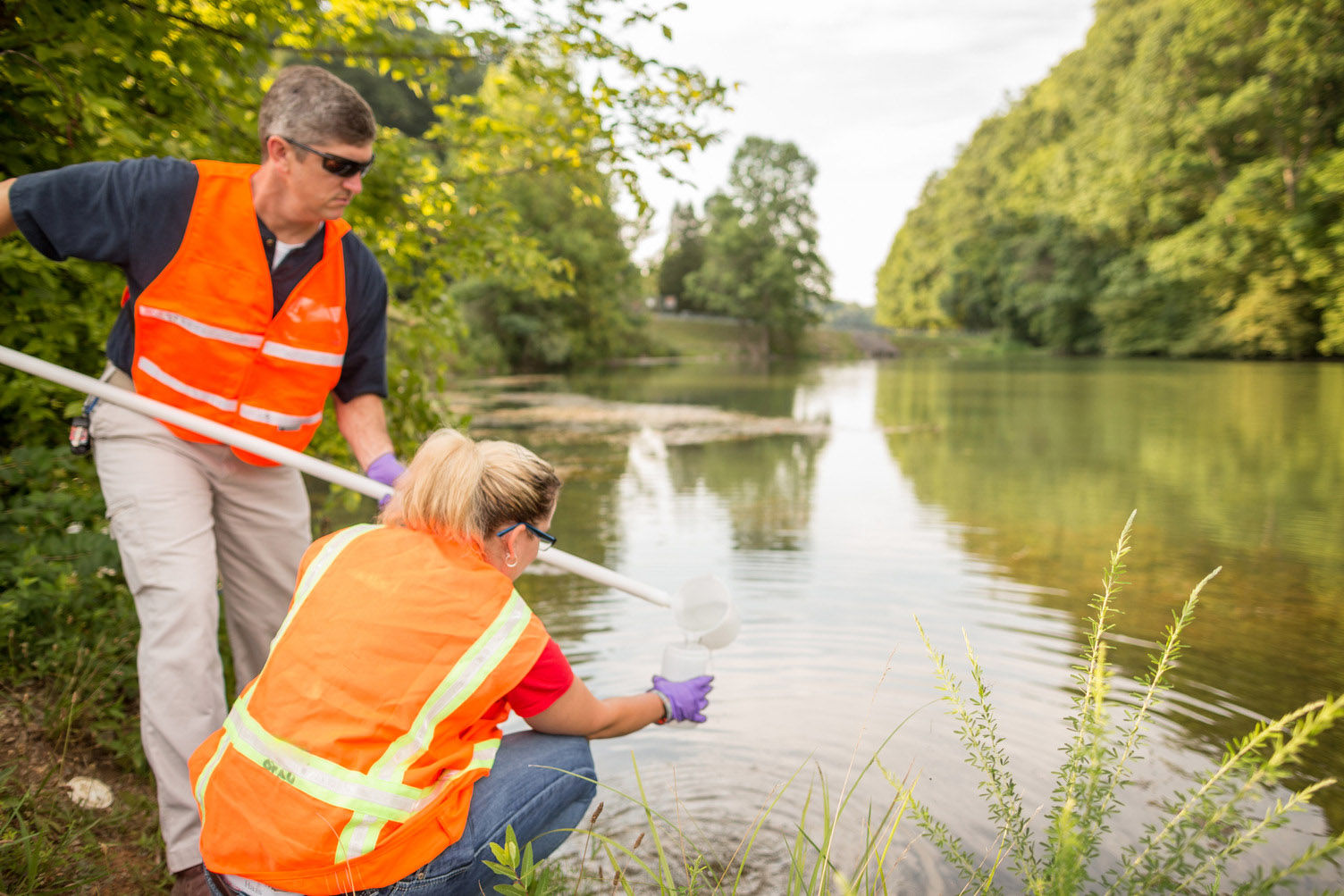 Health physicists perform a water sampling test