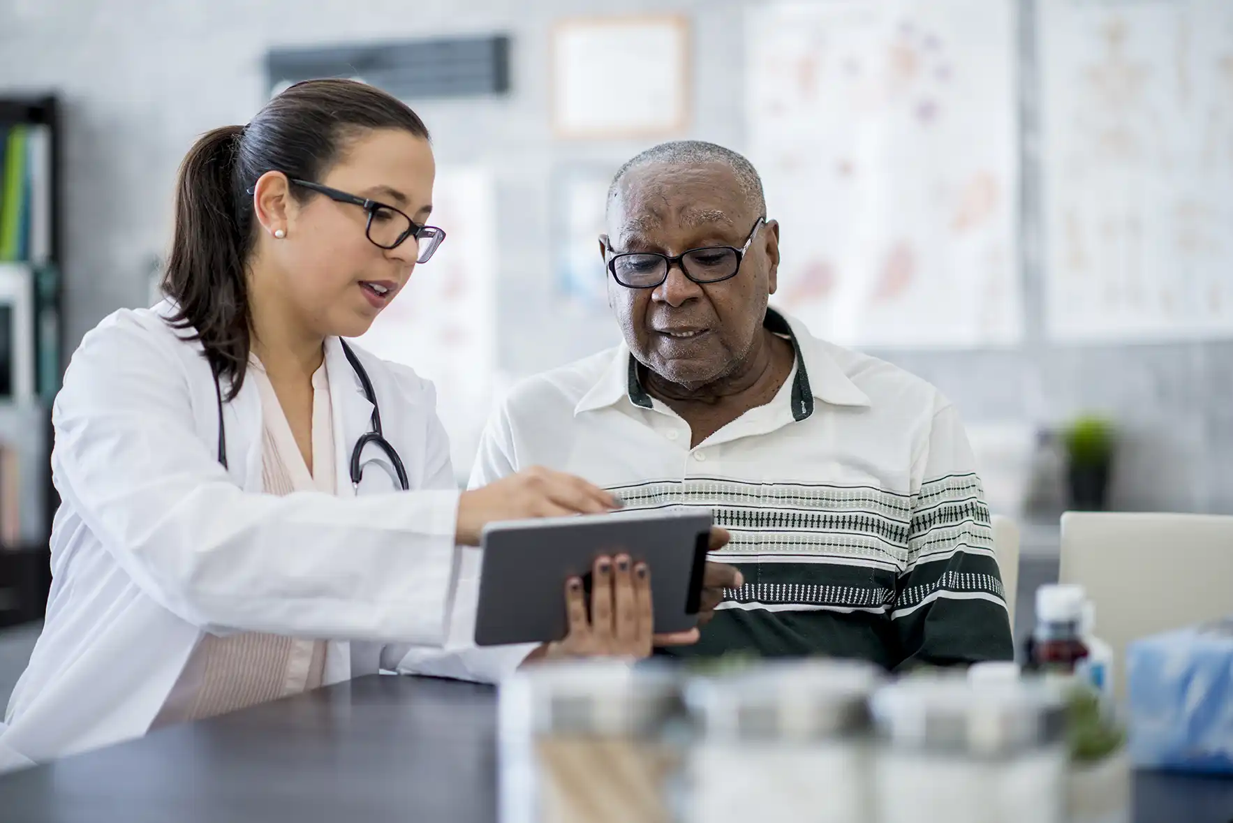 A female physician speaks to a male patient in a doctor's office