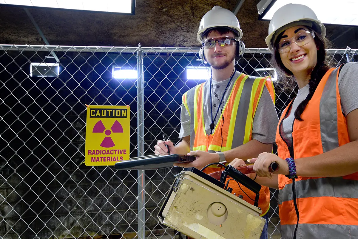 A male and female health physicist conduct an indoor radiation survey