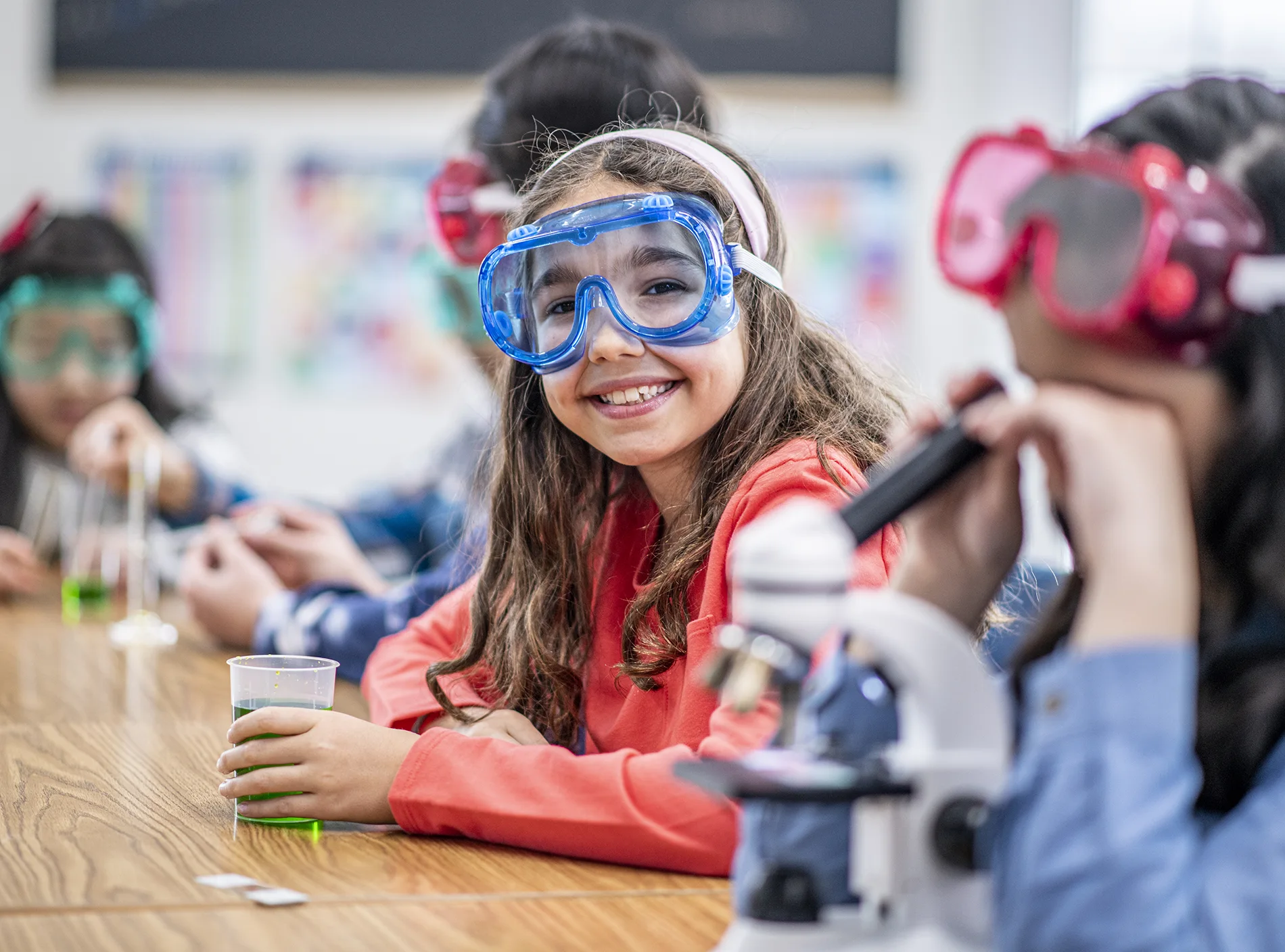 Male and female students building robot vehicle in after school computer coding class 