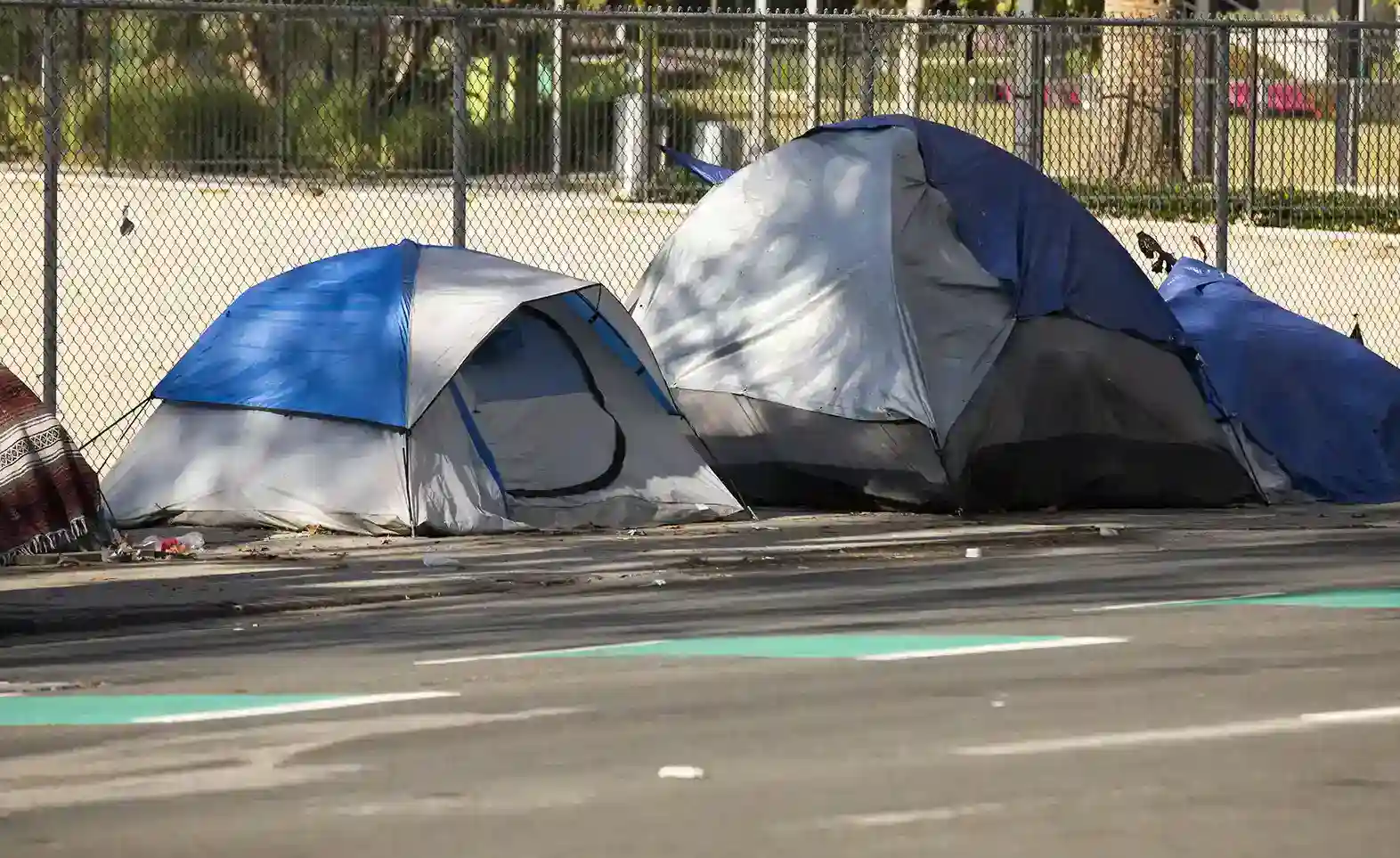Tents on sidewalk inferring homelessness