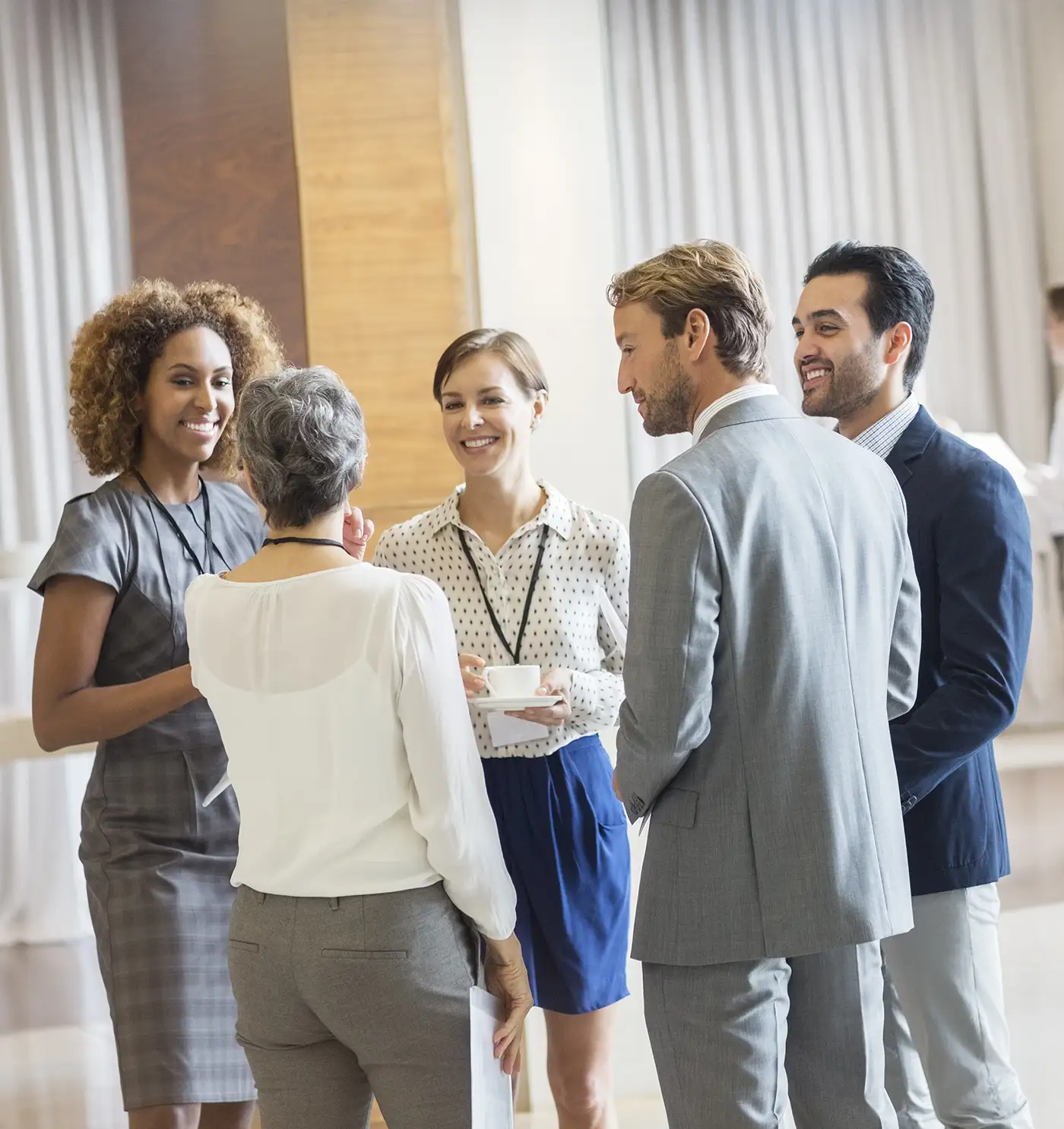 A group of diverse people talk in a large meeting area