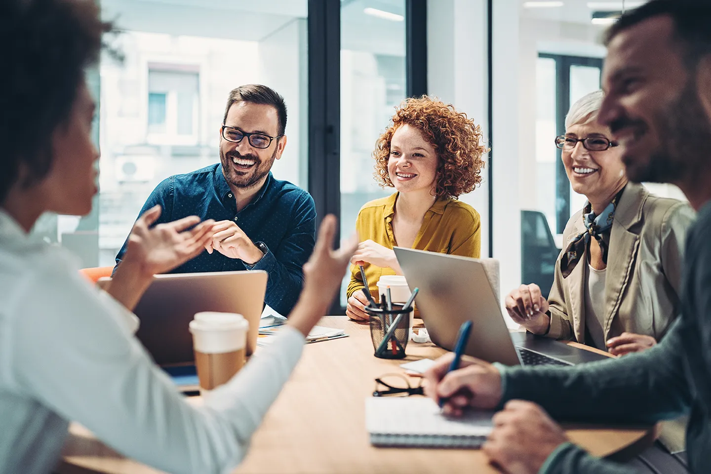 Focused employees group talk working together looking at laptop computer