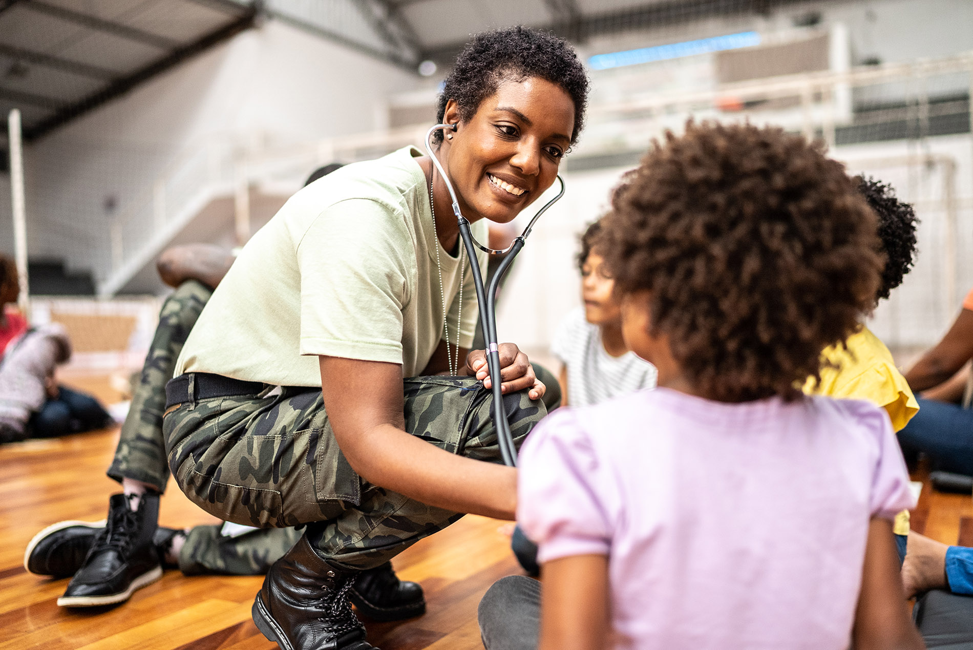 Army doctor examining children at a community center