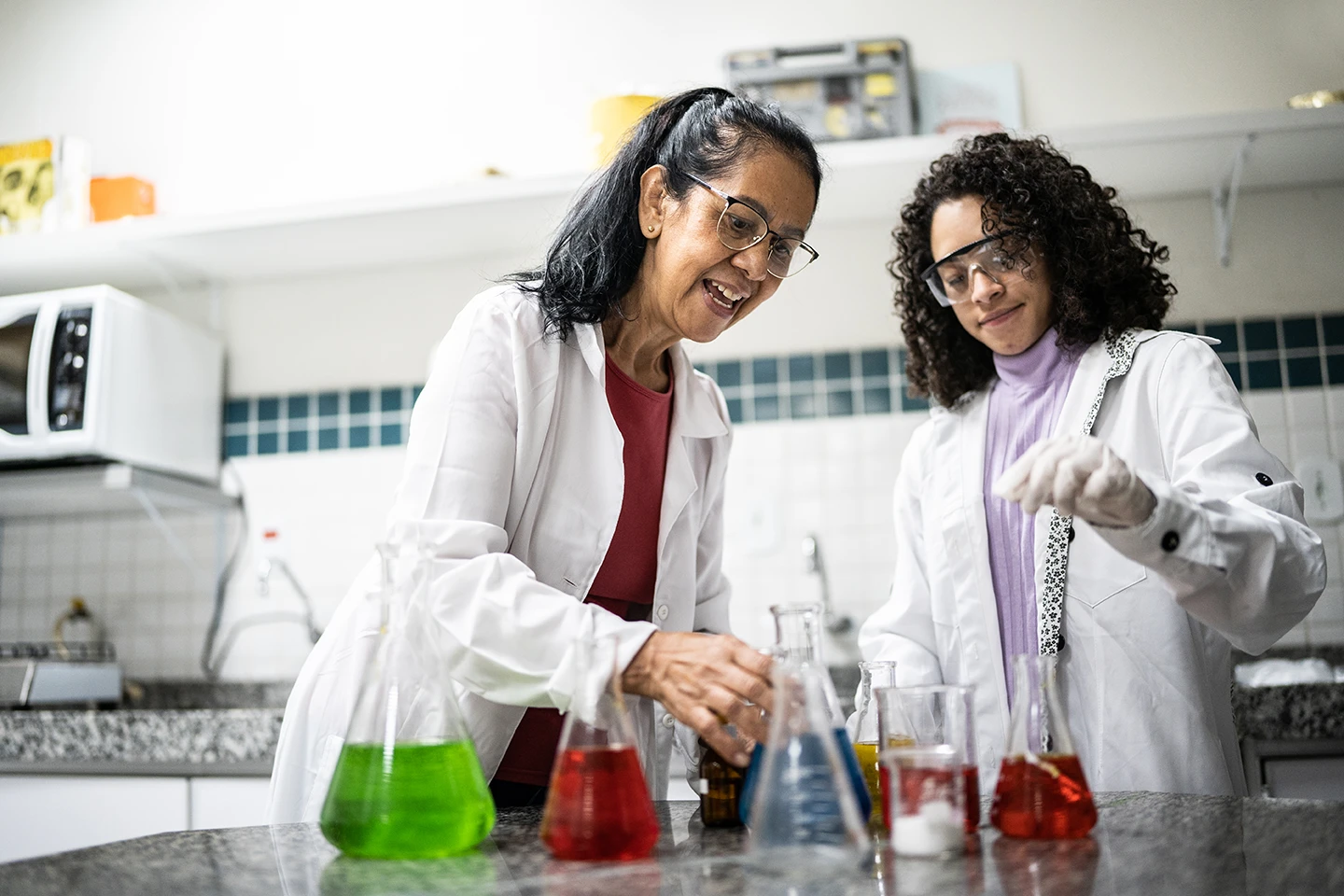 A female mentor and female student conduct research in a lab setting