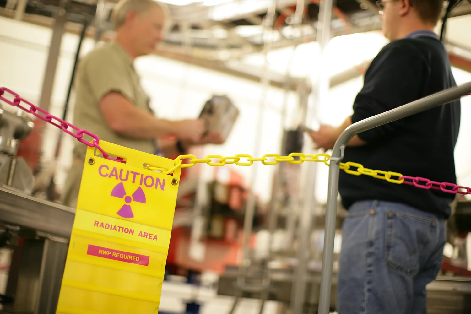 Two workers behind a radiation control line